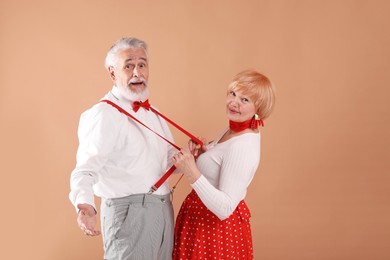 Photo of Lovely senior couple together on light brown background