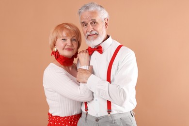Photo of Lovely senior couple together on light brown background
