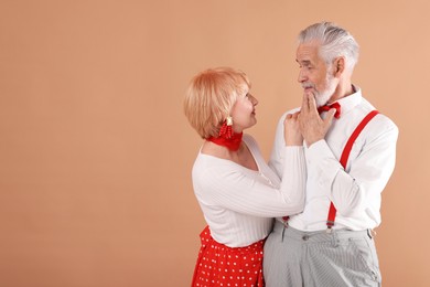 Photo of Lovely senior couple together on light brown background, space for text