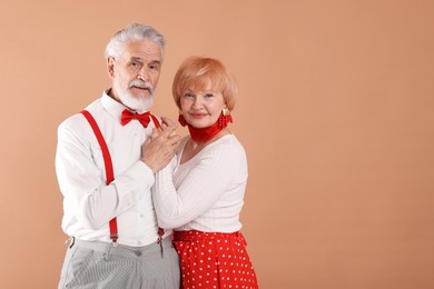 Photo of Lovely senior couple together on light brown background, space for text