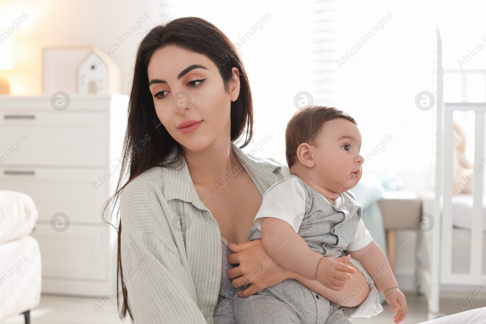 Woman suffering from postpartum depression with her little baby at home Photo of Woman suffering from postpartum depression with her little baby at home