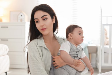 Photo of Woman suffering from postpartum depression with her little baby at home
