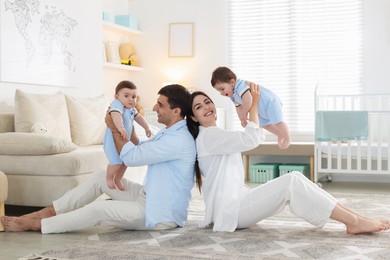 Photo of Happy family. Parents with their twin babies at home