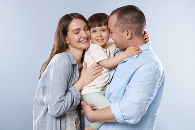 Photo of Happy parents and their baby boy on light grey background. Lovely family