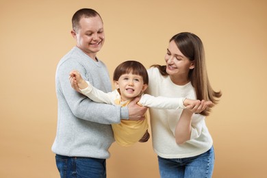 Photo of Happy parents and their baby boy on beige background. Lovely family