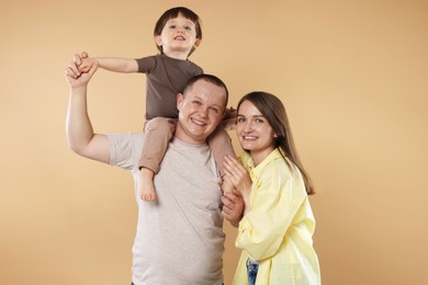 Photo of Happy parents and their baby boy on beige background. Lovely family