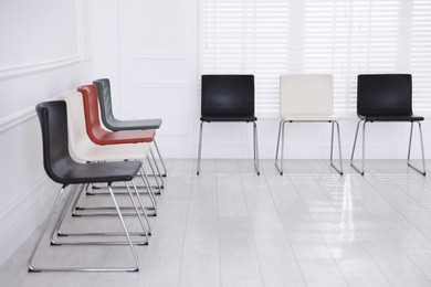 Photo of Colorful chairs near white wall in waiting room