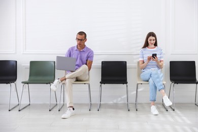 Photo of Man and woman waiting for appointment indoors