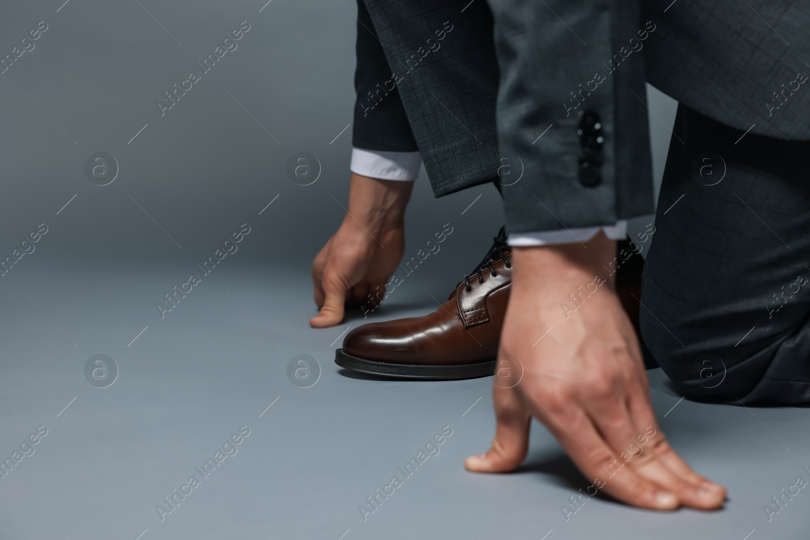 Businessman in starting position on gray background, closeup. Space for text Photo of Businessman in starting position on gray background, closeup. Space for text