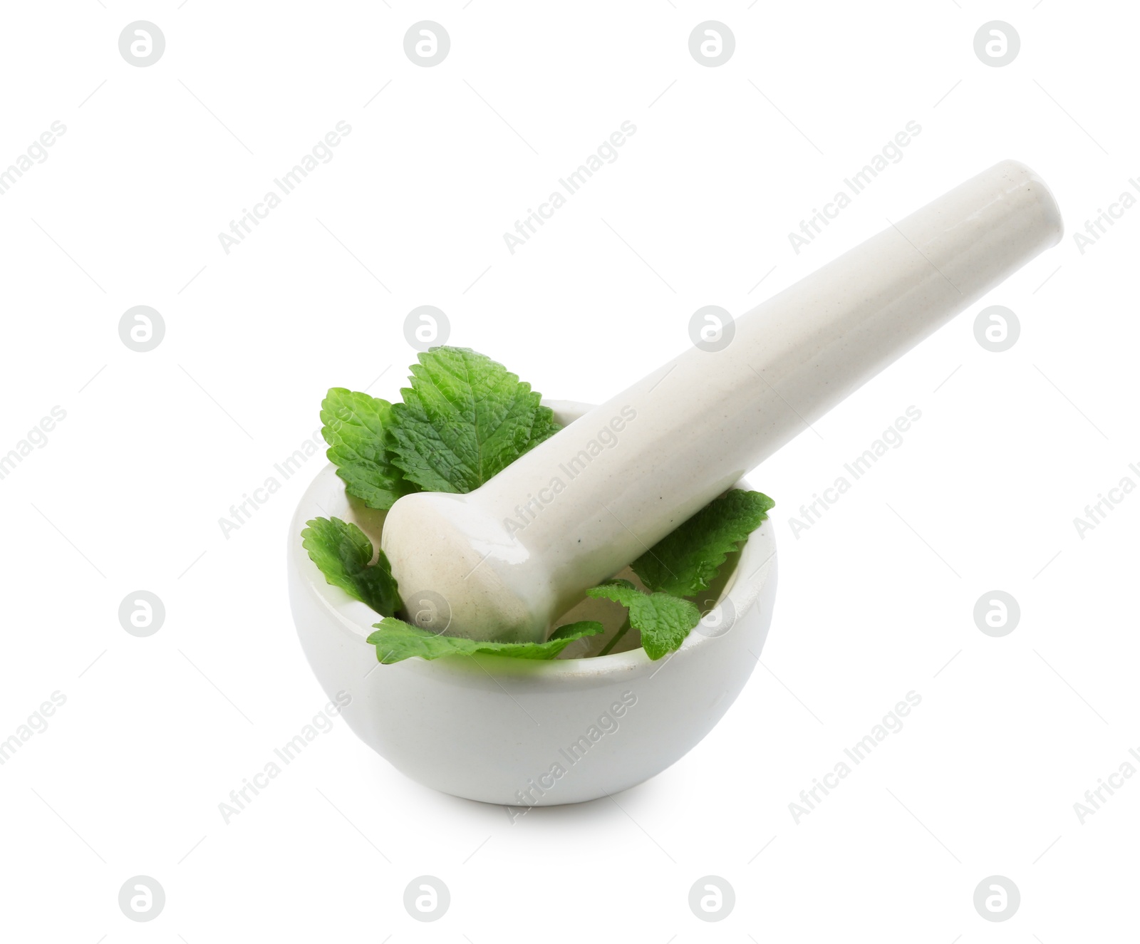 Fresh lemon balm leaves and pestle in mortar isolated on white Photo of Fresh lemon balm leaves and pestle in mortar isolated on white