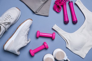 Photo of Sportswear, sneakers, skipping rope, headphones and dumbbells on grey background, flat lay