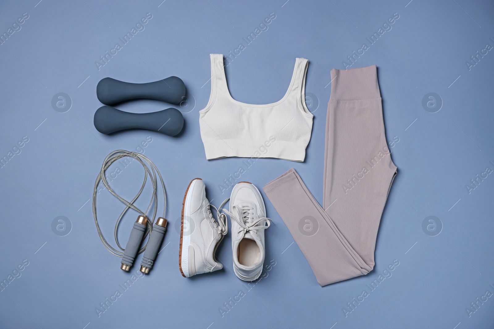 Sportswear, sneakers, skipping rope and dumbbells on grey background, flat lay Photo of Sportswear, sneakers, skipping rope and dumbbells on grey background, flat lay
