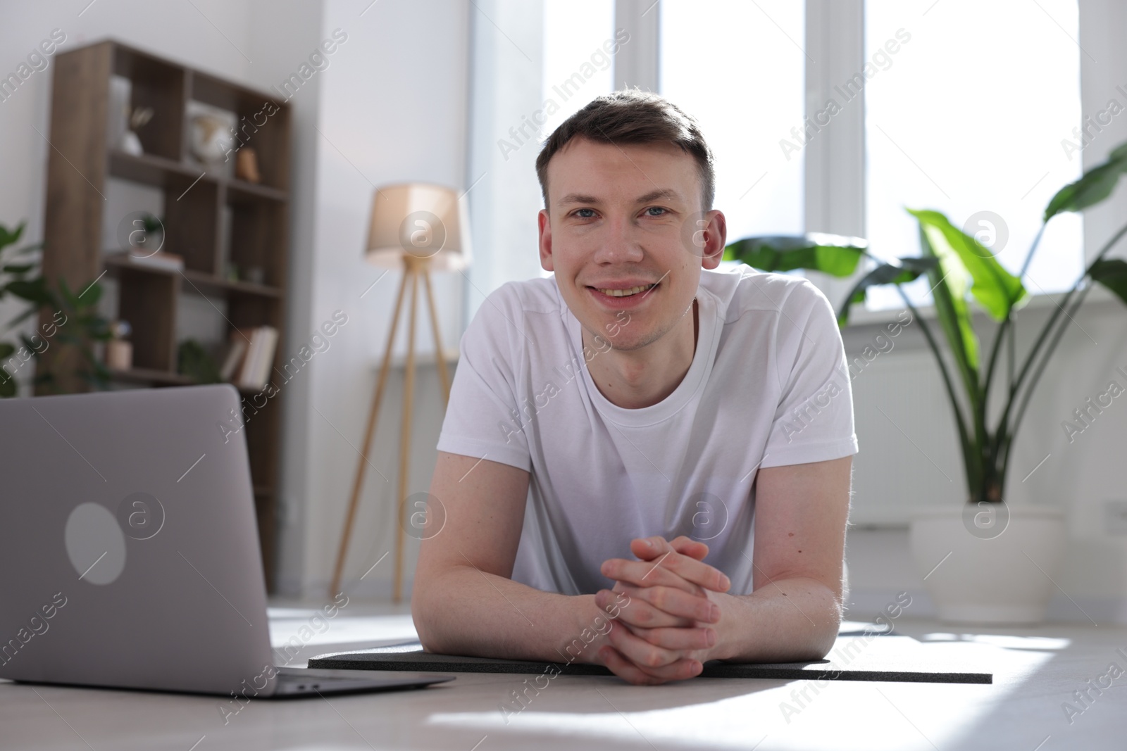 Man having online yoga class via laptop at home Photo of Man having online yoga class via laptop at home