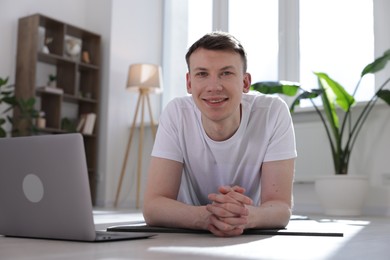 Photo of Man having online yoga class via laptop at home