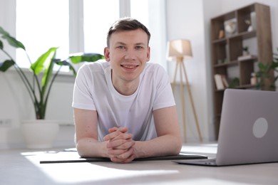 Photo of Man having online yoga class via laptop at home