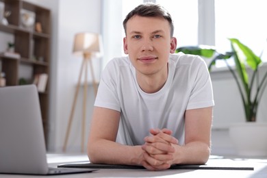 Photo of Man having online yoga class via laptop at home