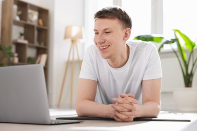 Photo of Man having online yoga class via laptop at home