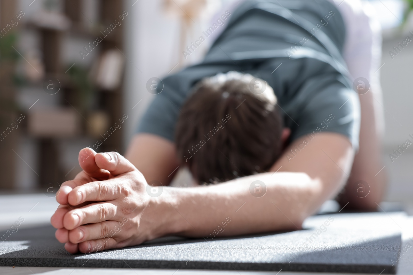 Young man practicing yoga at home, closeup Photo of Young man practicing yoga at home, closeup