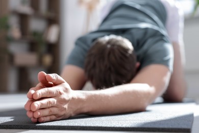 Photo of Young man practicing yoga at home, closeup