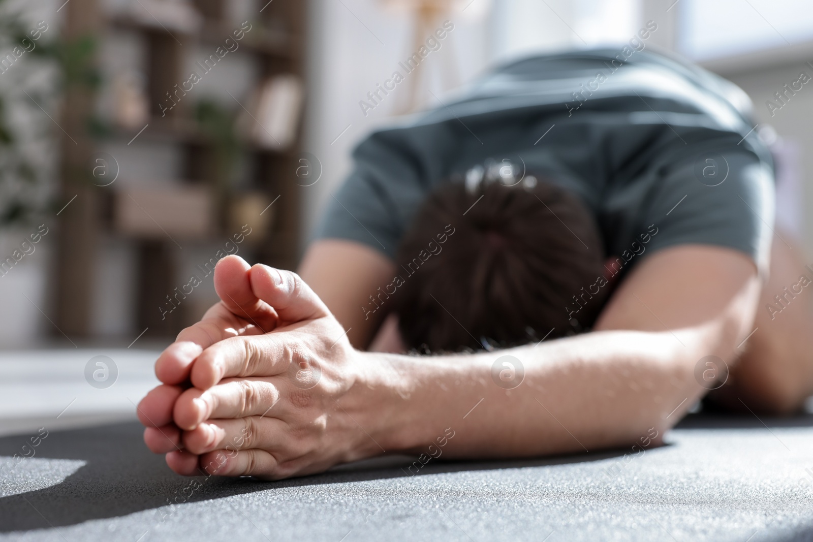 Young man practicing yoga at home, closeup Photo of Young man practicing yoga at home, closeup