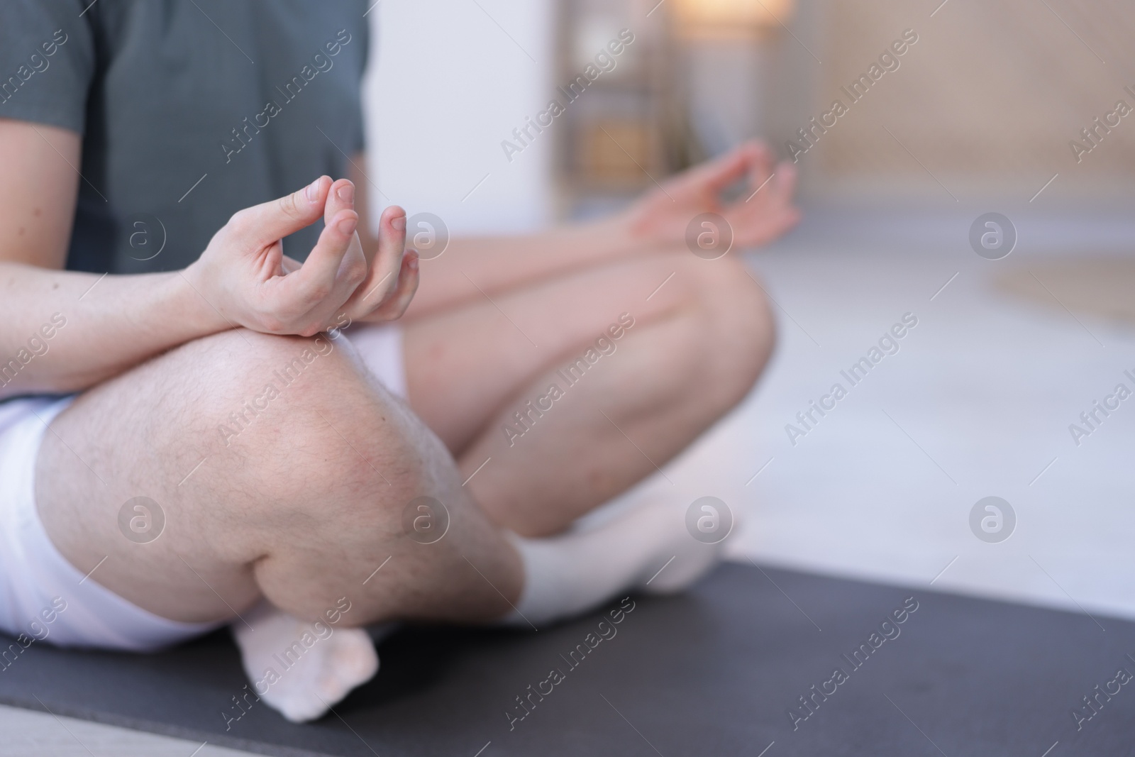 Young man practicing yoga at home, closeup Photo of Young man practicing yoga at home, closeup