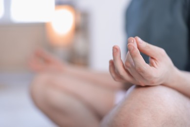 Photo of Young man practicing yoga at home, closeup