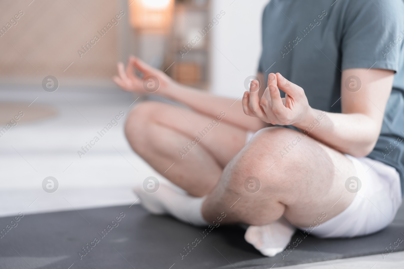 Young man practicing yoga at home, closeup Photo of Young man practicing yoga at home, closeup