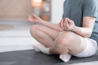 Photo of Young man practicing yoga at home, closeup