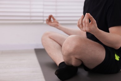 Photo of Young man practicing yoga at home, closeup