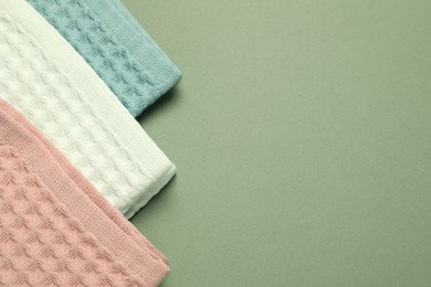 Photo of Clean waffle towels on green background, flat lay. Space for text