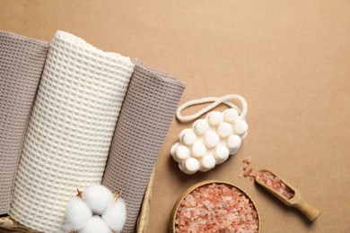 Photo of Clean waffle towels and cosmetic products on brown background, flat lay. Space for text