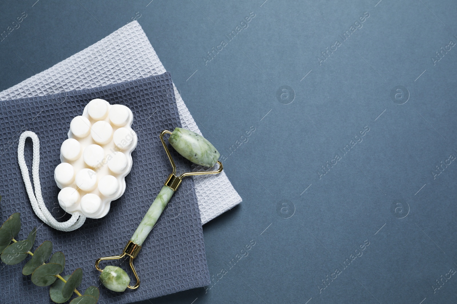 Clean waffle towels and cosmetic products on dark blue background, flat lay. Space for text Photo of Clean waffle towels and cosmetic products on dark blue background, flat lay. Space for text