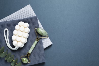 Photo of Clean waffle towels and cosmetic products on dark blue background, flat lay. Space for text