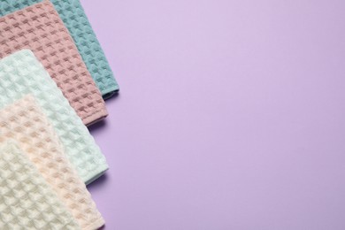 Photo of Clean waffle towels on violet background, flat lay. Space for text