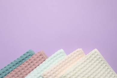 Photo of Clean waffle towels on violet background, flat lay. Space for text