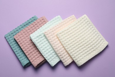 Photo of Clean waffle towels on violet background, flat lay