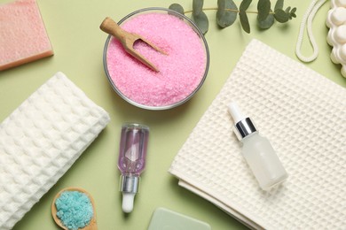 Photo of Clean waffle towels and cosmetic products on light green background, flat lay