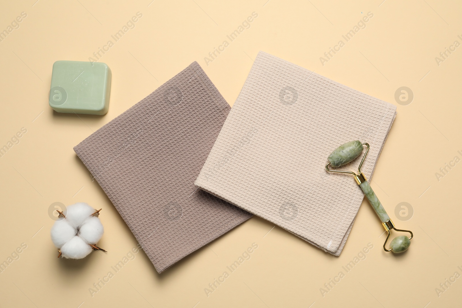 Clean waffle towels and cosmetic products on beige background, flat lay Photo of Clean waffle towels and cosmetic products on beige background, flat lay