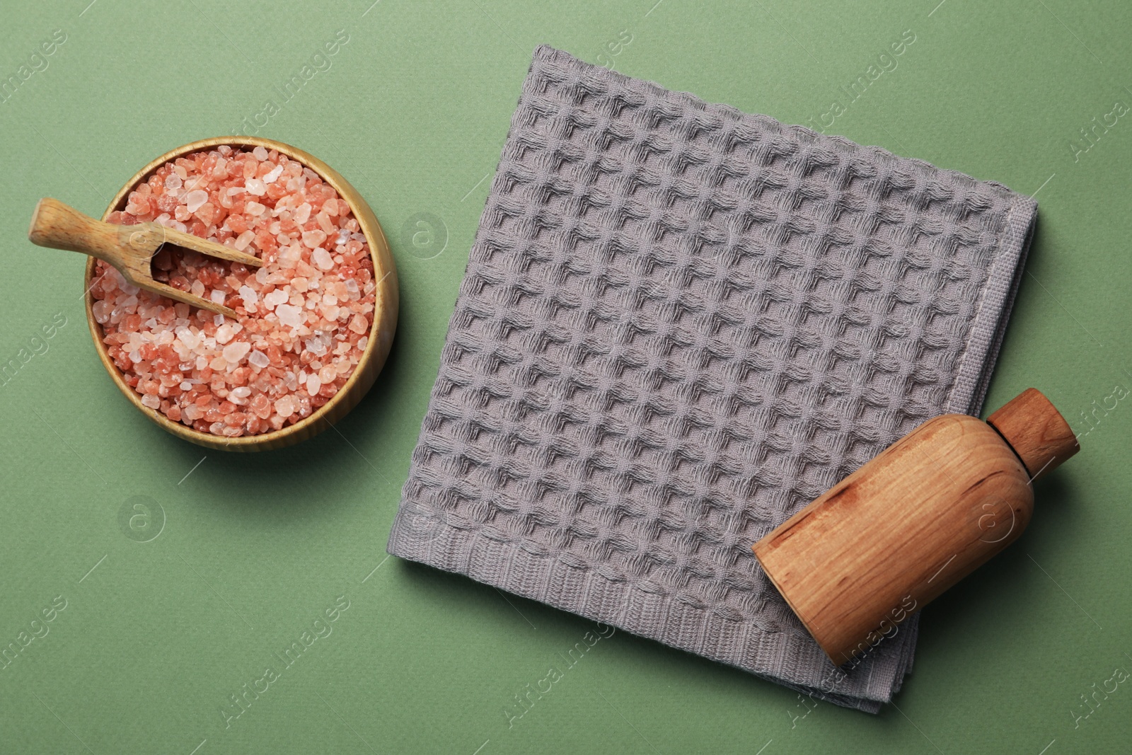 Clean waffle towel and cosmetic products on green background, flat lay Photo of Clean waffle towel and cosmetic products on green background, flat lay