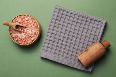 Photo of Clean waffle towel and cosmetic products on green background, flat lay