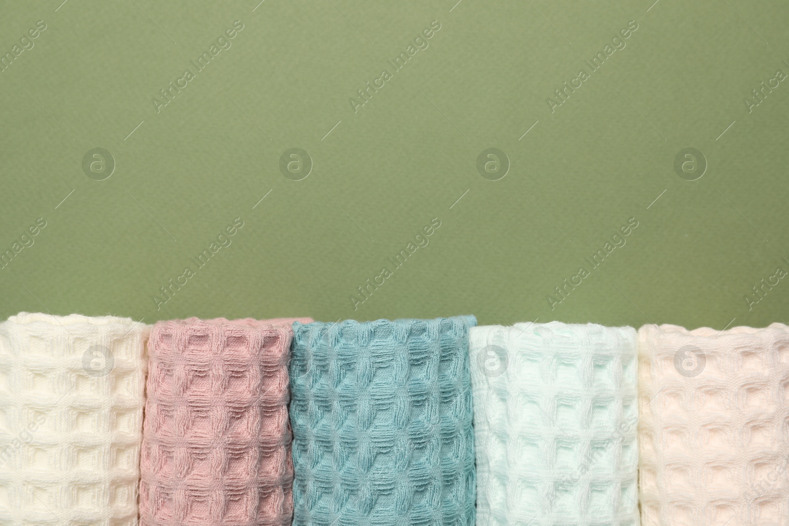 Clean waffle towels on green background, flat lay. Space for text Photo of Clean waffle towels on green background, flat lay. Space for text