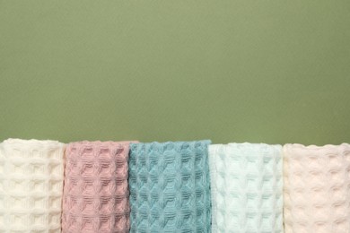 Photo of Clean waffle towels on green background, flat lay. Space for text