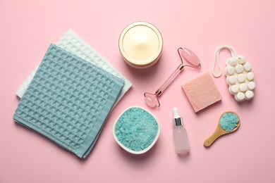 Photo of Clean waffle towels and cosmetic products on light pink background, flat lay