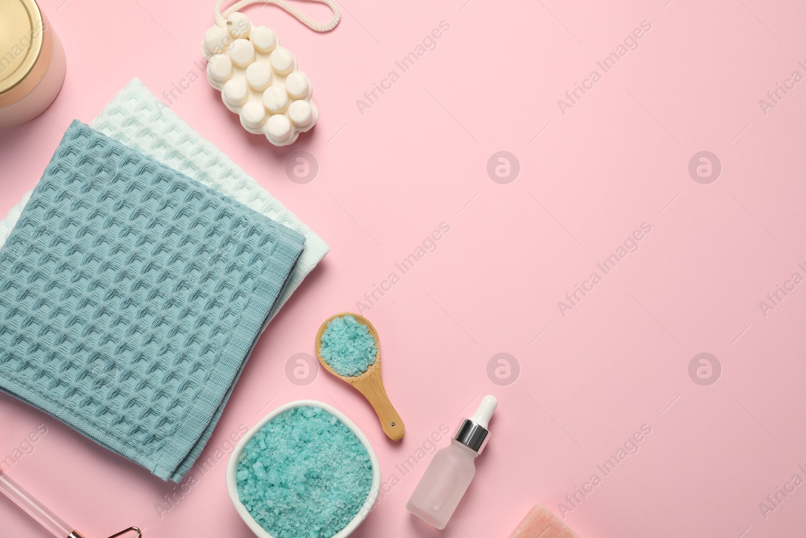 Clean waffle towels and cosmetic products on light pink background, flat lay. Space for text Photo of Clean waffle towels and cosmetic products on light pink background, flat lay. Space for text
