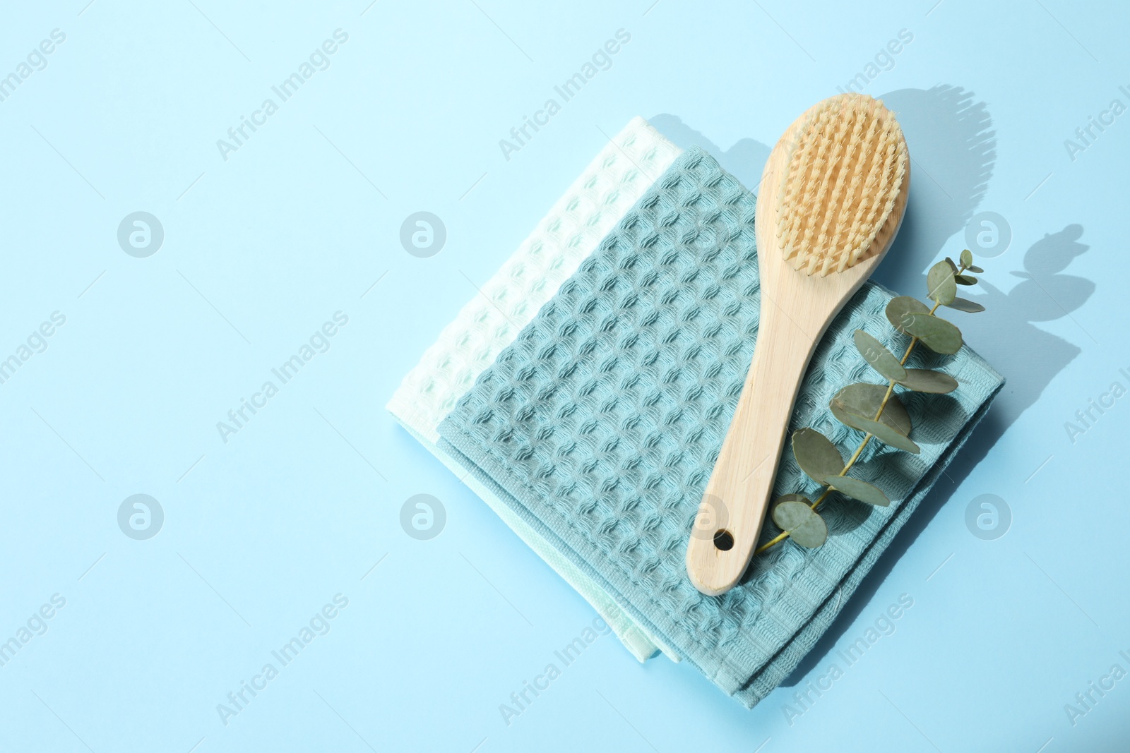 Clean waffle towels and cosmetic products on light blue background, flat lay. Space for text Photo of Clean waffle towels and cosmetic products on light blue background, flat lay. Space for text