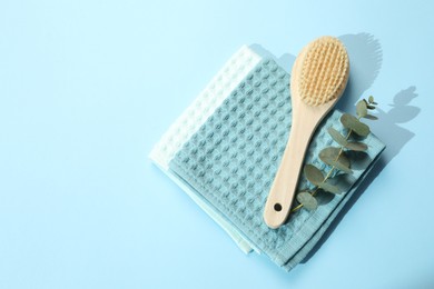 Photo of Clean waffle towels and cosmetic products on light blue background, flat lay. Space for text