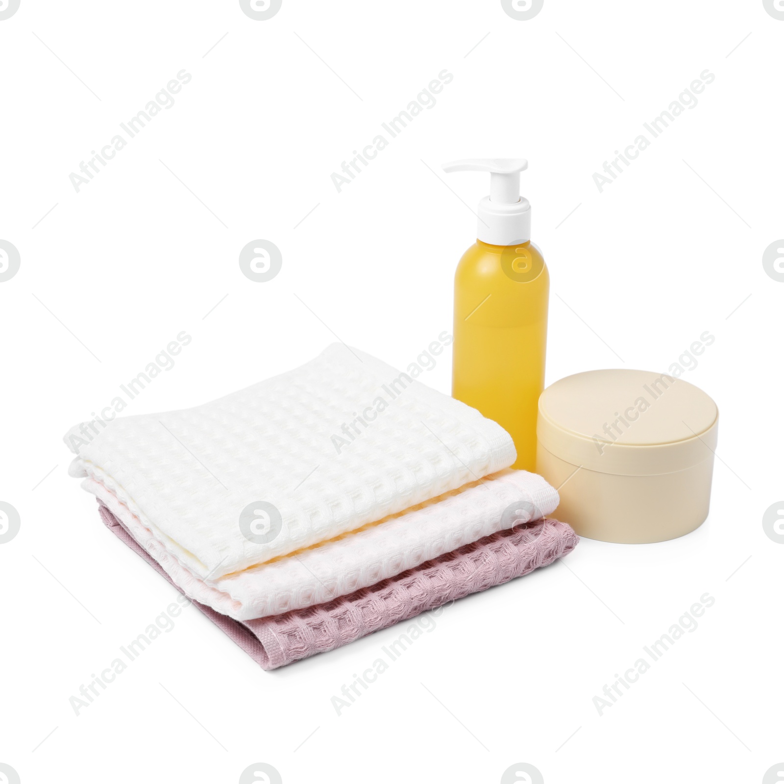 Clean waffle towels and cosmetic products isolated on white Photo of Clean waffle towels and cosmetic products isolated on white