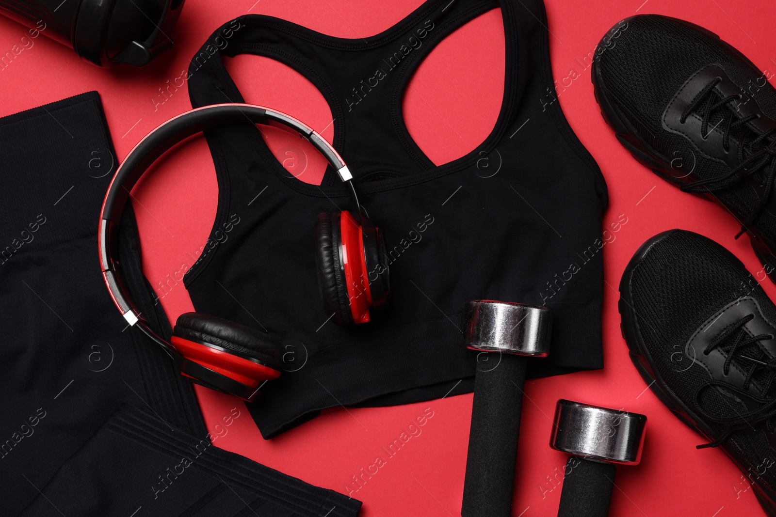 Sportswear, sneakers, dumbbells, headphones and water bottle on red background, flat lay Photo of Sportswear, sneakers, dumbbells, headphones and water bottle on red background, flat lay