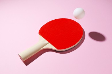 Photo of Ping pong racket and ball on pink background