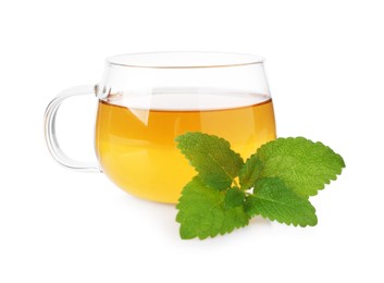 Photo of Aromatic lemon balm tea in glass cup and fresh leaves isolated on white